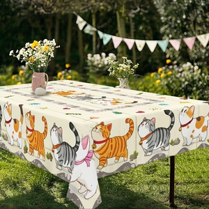 Detail of warm beige tablecloth with cute cartoon cats in a sunny garden setting