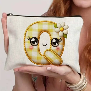 Detailed close-up of a canvas pouch with a yellow letter Q cartoon and floral print