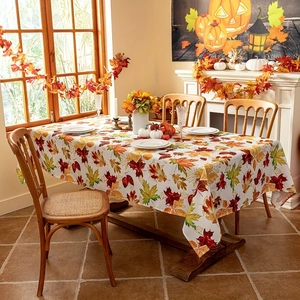 Detail of autumn maple leaf pattern tablecloth on a festive Thanksgiving dining table set