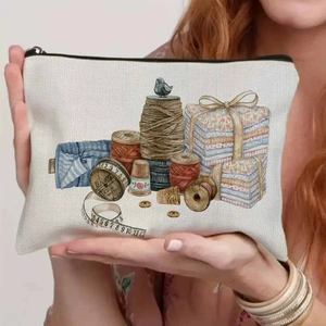 Vintage canvas cosmetic bag with sewing print held by a hand, showing its compact size