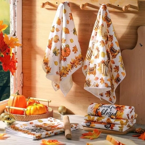 Close-up of microfiber kitchen towel with pumpkin, maple leaf prints and autumn gnome design