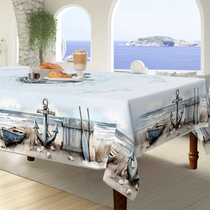 Detail of nautical tablecloth featuring realistic anchor and boat prints on wood table