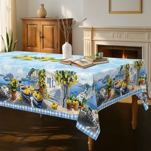 Detail of Mediterranean tablecloth with lemon and coastal town print on wooden table
