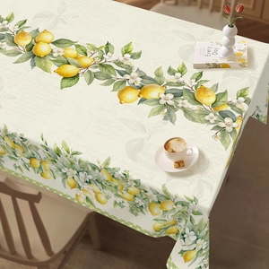 Detailed view of floral summer tablecloth with yellow lemon pattern and cotton texture