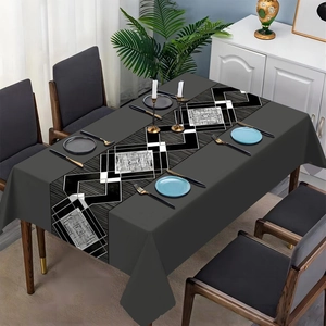 Detail of dark grey tablecloth with geometric diamond pattern in modern dining setting