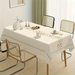 Detailed close-up of cream-colored floral tablecloth on a wooden table in home setting