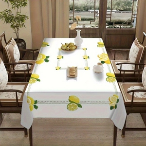 Detail of waterproof summer tablecloth featuring fresh lemon patterns and green leaves