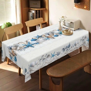 Detailed view of ocean theme tablecloth with blue starfish and seashells on a wooden table