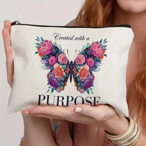 Close-up of canvas makeup bag with colorful floral butterfly and artistic purpose quote
