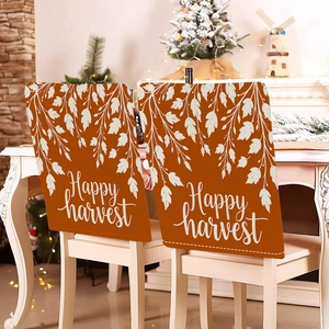 Set of two Thanksgiving chair back covers featuring maple leaves and Happy Harvest text