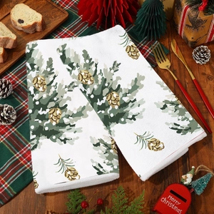 Close-up of festive Christmas kitchen towels with pine branch and cone print on wood