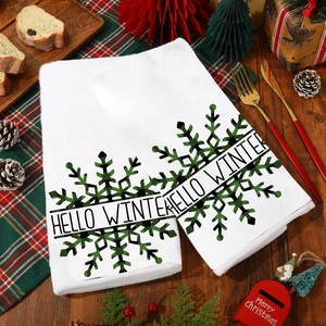 Close-up of Hello Winter snowflake towels set against a festive wooden table backdrop