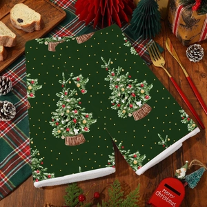 Detail view of dark green Christmas tree kitchen towels on a festive wooden table