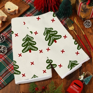 Set of two white Christmas hand towels with festive green tree and red star patterns