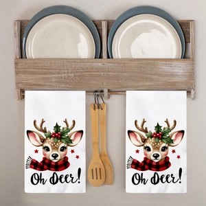Detail of two white kitchen towels with reindeer pattern and Oh Deer text on a wooden rack