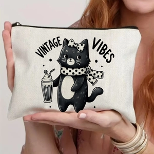 Close-up of vintage cat print on cream canvas zipper pouch held by a model