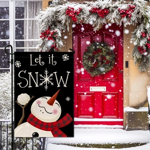Close-up of winter snowman garden flag with Let it SNOW text against snowy porch background