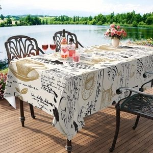 Détail d'une nappe vintage imprimé café sur une terrasse en bois avec vue sur le lac