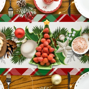 Detailweergave van de kersttafelloper met feestelijke boomprints op een houten eettafel