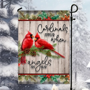 Detailed garden flag with cardinals and pine branches on a rustic gray wood background