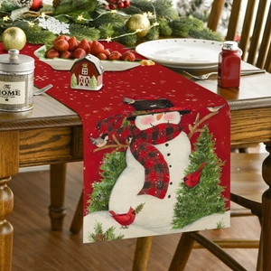 Detail van kersttafelloper met prints van sneeuwpop, kardinaal en kerstbomen