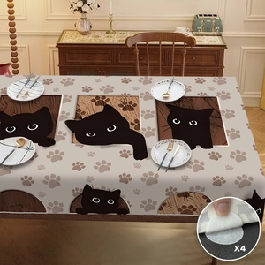 Détail de nappe beige avec motifs de chats noirs et quatre autocollants antidérapants