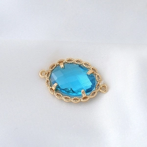 Detaillierte Makroansicht des ovalen blauen Edelsteinanhängers mit goldener Spitzenfassung
