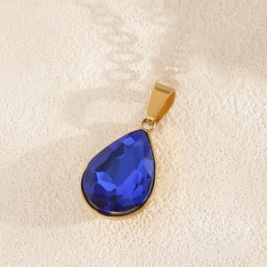 Macro-opname van de vergulde druppelvormige hanger met blauwe kristallen detail