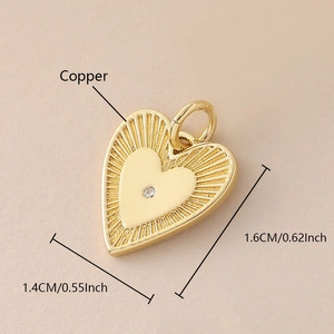 Detalle del colgante de sobre con forma de corazón en cobre bañado en oro con un cristal