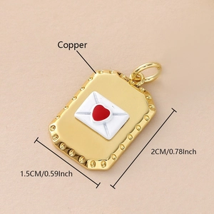 Detalle de un colgante de sobre en cobre dorado de 2cm con corazón esmaltado rojo