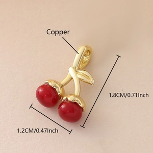 Detailed macro view of cherry charm with red enamel and gold finish showing dimensions