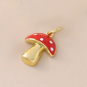 Detail of a gold-plated mushroom pendant with red enamel and white polka dots