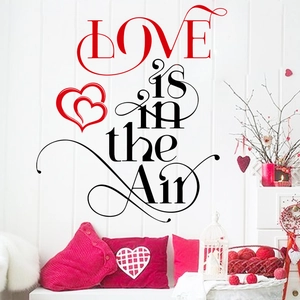 LOVE is in the Air wall sticker with red hearts on white wall with romantic decor