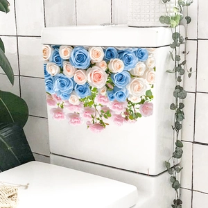 Detail of floral toilet tank decals with blue and pink roses on white ceramic surface