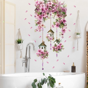 Floral wall sticker with pink cherry blossoms and small house charms above white bathtub