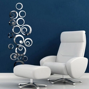 Detail view of silver acrylic mirror circle wall stickers on a modern blue living room wall