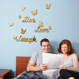 Detailed view of golden mirror butterfly and Live Love Laugh wall stickers in a bedroom