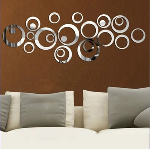 Silver acrylic mirror wall stickers with circular 3D design above a modern white sofa