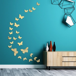 Macro view of 3D gold butterfly mirror wall stickers on a modern living room wall