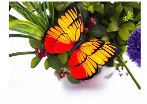 Macro shot of vibrant double-layered orange PVC butterfly stake in garden green setting