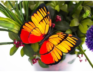 Close-up of a 3D double-layered PVC butterfly with orange and yellow patterns for garden decor