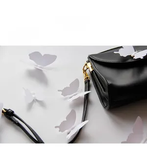 3D white decorative butterflies arranged on a leather surface for wedding party decor