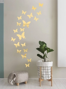 Golden mirror butterfly wall stickers arranged in a spiral on a living room wall