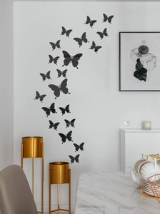 Detail view of 3D black butterfly wall stickers in a realistic flying arrangement on a white wall
