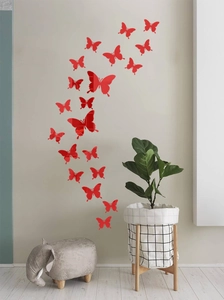 Macro detail of red 3D mirror butterfly wall stickers arranged on a modern grey wall