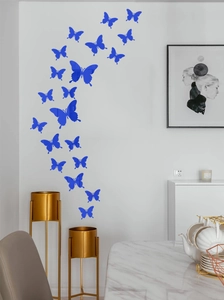 Blue butterfly 3D mirror wall stickers clustered on a white wall in a modern living room