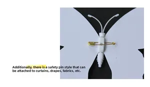 Detail view of the metal safety pin attachment on the back of a white 3D PVC butterfly