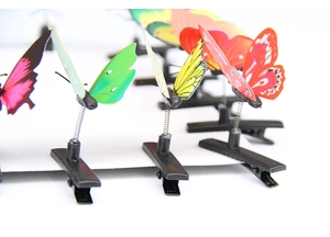 Macro view of colorful butterfly hair clips with flexible springs on white cardboard