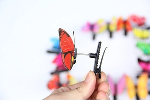 Detail of red butterfly hair clip with spring mechanism for flexible movement