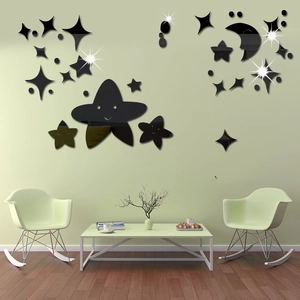 Detail view of black acrylic moon and star mirror wall stickers on a green bedroom wall